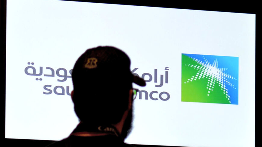 A man looks at the exchange board at the Stock Exchange Market (Tadawul) bourse in Riyadh displaying Aramco shares on the second day of their trading on December 12, 2019.