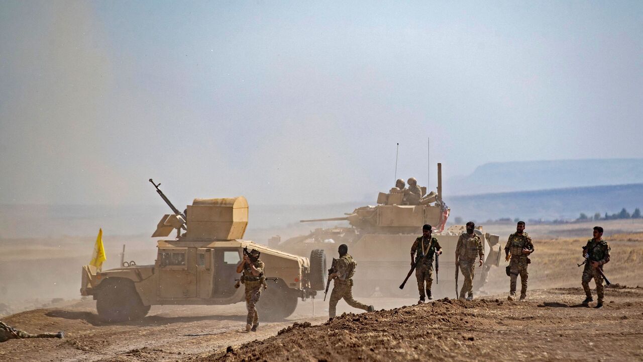 Fighters of the Syrian Democratic Forces (SDF) gather near a US Bradley Fighting Vehicle (BFV) during a joint military exercise with forces of the US-led "Combined Joint Task Force-Operation Inherent Resolve" coalition against the Islamic State (IS) group in the countryside of the town of al-Malikiya (Derik in Kurdish) in Syria's northeastern Hasakah province on Sept. 7, 2022.