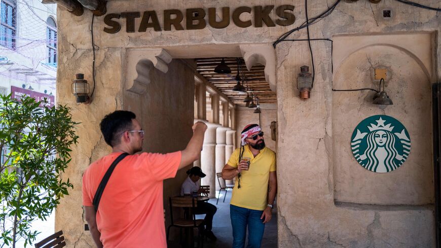 A man poses for video outside a Starbucks coffee shop in a market area in Dubai on May 18, 2023.