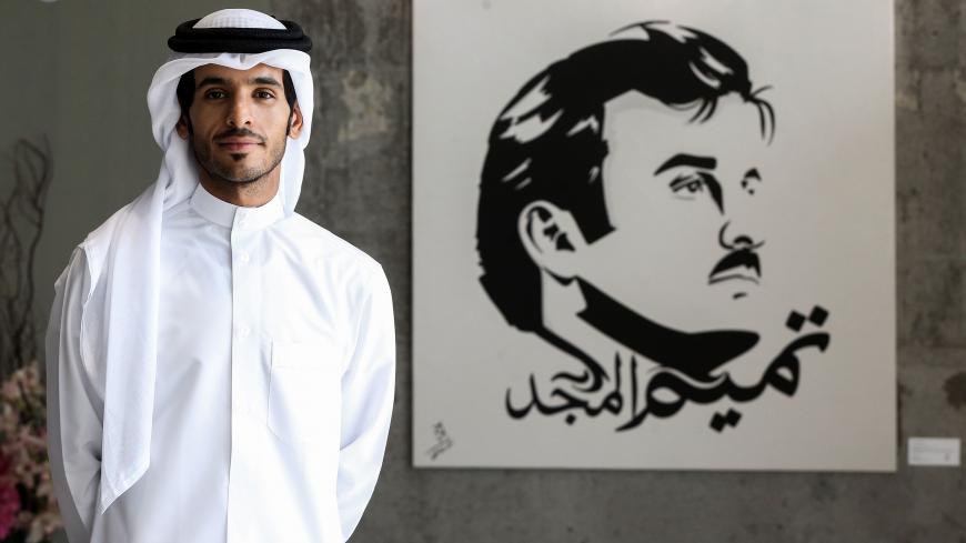 Qatari artist Ahmed Bin Majed Al-Maadheed stands next to his painting of Qatari Emir Tamim bin Hamad al-Thani titled "Glorious Tamim" at a gallery in Doha on July 28, 2017.
Maadheed's painting of the Qatari Emir has been spread widely on social media since Saudi Arabia, Bahrain, the United Arab Emirates and Egypt broke ties with Qatar on June 5, transforming the artist into a star. / AFP PHOTO / STRINGER / RESTRICTED TO EDITORIAL USE - MANDATORY MENTION OF THE ARTIST UPON PUBLICATION - TO ILLUSTRATE THE