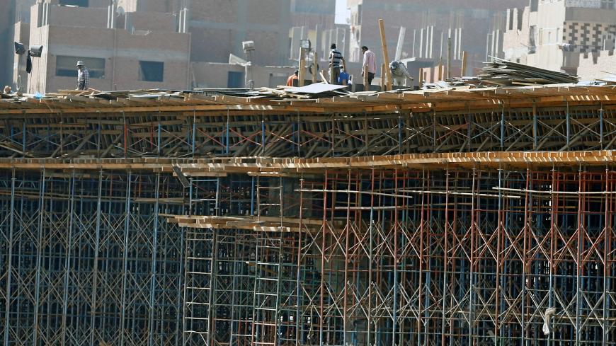Construction labourers work on a bridge to link the Cairo-Banha highway at the agricultural road which leads to the capital city of Cairo, Egypt October 13, 2016. Picture taken October 13, 2016. REUTERS/Amr Abdallah Dalsh - RTSS9FW