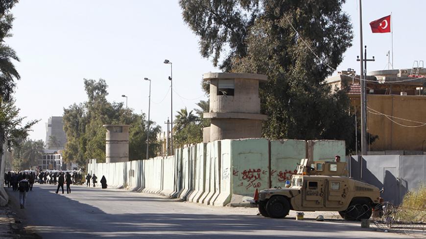 Iraqi security forces stand guard with their military vehicle outside the Turkish embassy in Baghdad December 8 2015.  REUTERS/Khalid al-Mousily  - RTX1XPHA