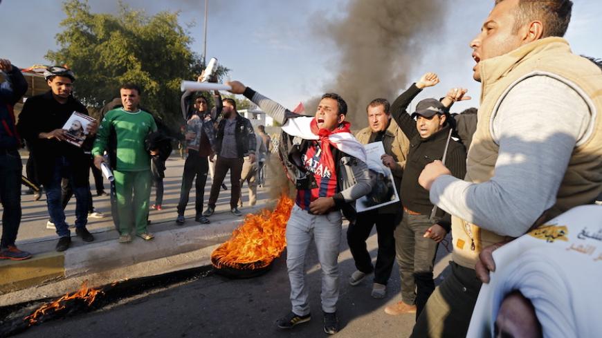 Supporters of Shi'ite cleric Moqtada al-Sadr shout as they stand near a burning tyre during a demonstration against the execution of Shi'ite Muslim cleric Nimr al-Nimr in Saudi Arabia, in Baghdad, Iraq January 4, 2016. REUTERS/Thaier Al-Sudani - RTX20ZMU