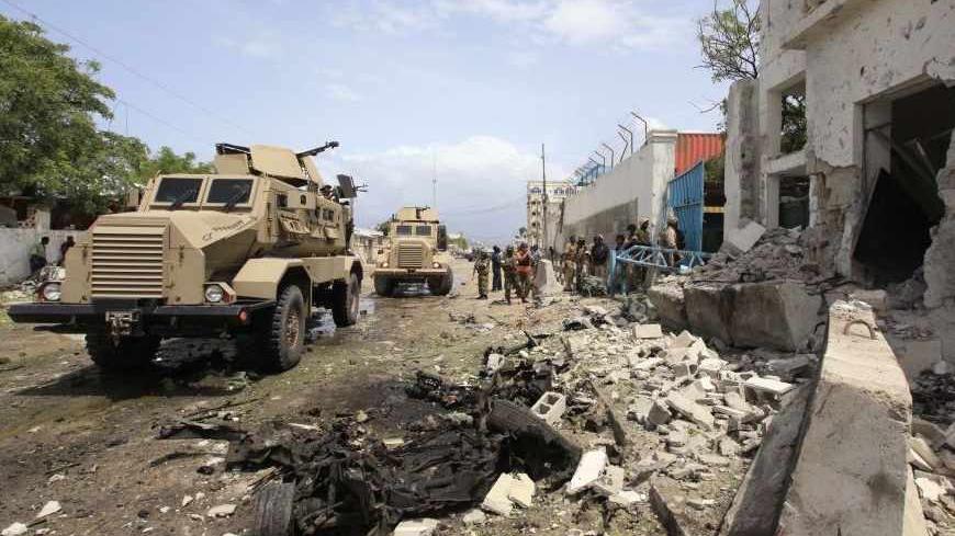 African Union Mission in Somalia (AMISOM) secure the scene of a suicide bomb attack outside the United Nations compound in Somalia's capital Mogadishu, June 19, 2013. A suicide bomber and several gunmen attacked a United Nations compound in the Somali capital Mogadishu on Wednesday, police and witnesses said, in a strike that bore the hallmarks of al Qaeda-linked militants. REUTERS/Feisal Omar (SOMALIA - Tags: SOCIETY CIVIL UNREST CRIME LAW MILITARY) - RTX10TBM